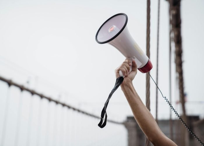 pexels photo 8898633 8898633 A hand holding a megaphone, symbolizing protest or announcement at an outdoor rally.